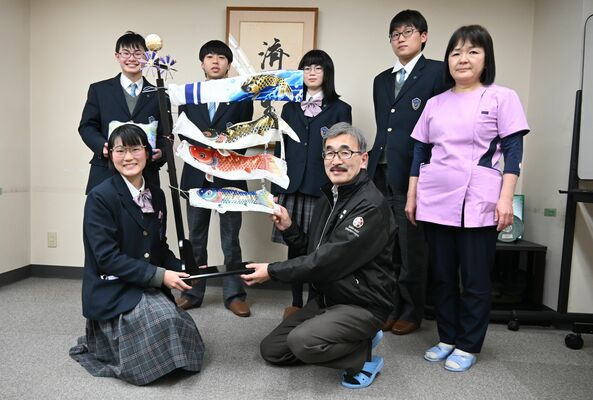 生徒からこいのぼり飾りを受け取る荻津院長（前列右）