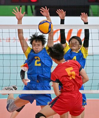 第１セット、相手のスパイクをブロックする足大付の荒井（左）と岩岡
