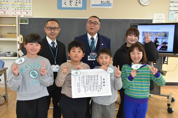 感謝状を手にする児童と中川会長（２列目中央）ら