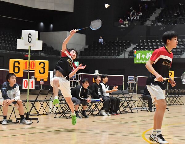 バドミントン男子団体優勝決定戦　作新の松本（左）がスマッシュを放つ。右は村山＝日環アリーナ栃木、鈴木航撮影