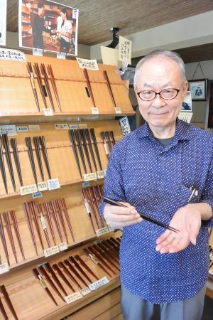 八角削りの箸を手にする大黒屋の竹田勝彦さん=東京都墨田区