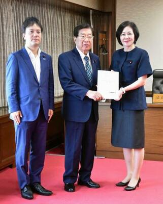 　提言を受け取る平口法相（中央）。右は日本維新の会の三木圭恵衆院議員＝２６日午前、法務省
