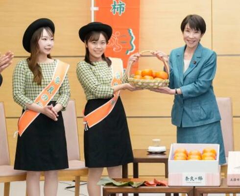 　奈良県特産の柿を贈呈される高市首相（右）＝１９日、首相官邸