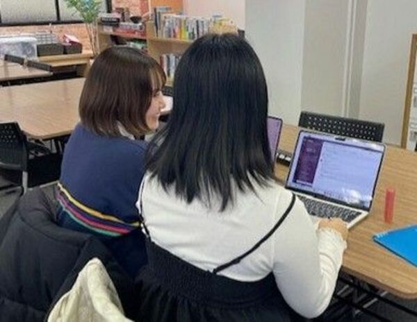 宇都宮市内にある私立通信制高の校舎で、友人(左)と語らうAさん(Aさん提供)