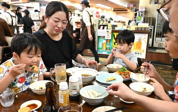 宇都宮餃子を味わう家族＝３日午前、宇都宮市馬場通り２丁目
