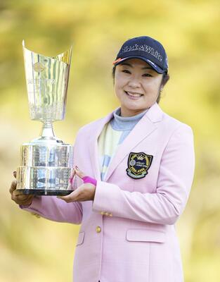 通算21アンダーで逆転優勝し、カップを手に笑顔の藤田＝エリエールＧＣ松山