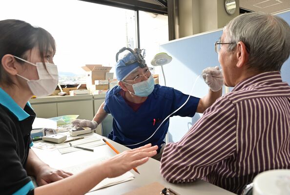 昨年度購入した舌圧測定器で健診を行う歯科医師