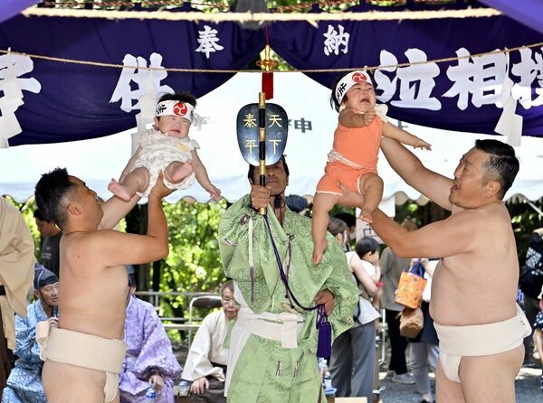 力士姿の氏子に抱えられて、元気な泣き声を響かせる子どもたち＝21日午前10時10分、鹿沼市樅山町