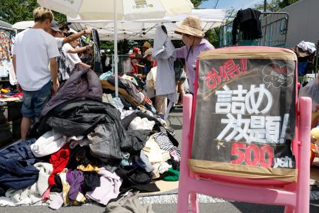 　フリーマーケットの詰め放題コーナーで買い物する人たち＝６日、東京都品川区
