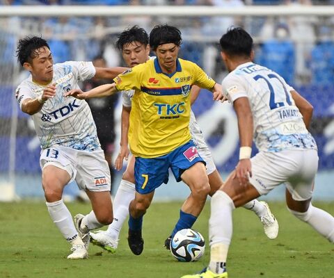 後半35分、相手の激しいマークを受ける栃木ＳＣのＭＦ西谷（中央）＝県グリーンスタジアム