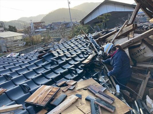 倒壊した住宅から被災者の思い出の品を取り出す米山さん＝９日午後、石川県輪島市（米山さん提供）