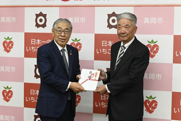 石坂市長（左）に目録を手渡す大根田さん