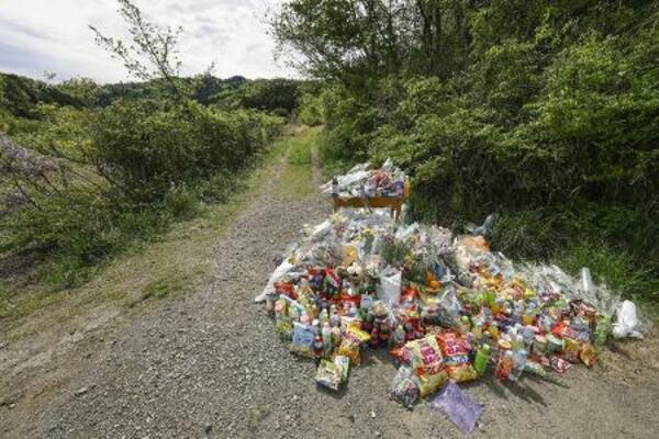　遺体が遺棄された現場付近に供えられた花や飲み物など＝４月２２日、京都府南丹市