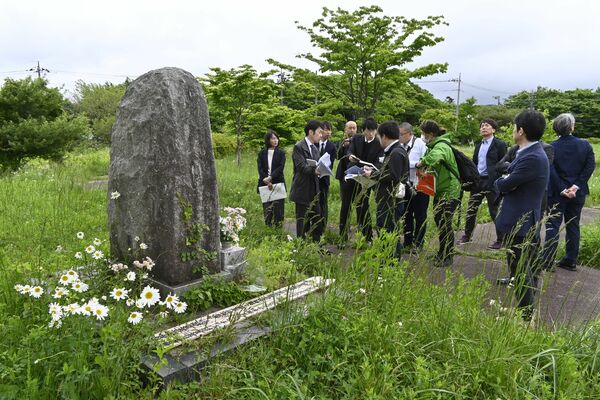 第2、3、5サティアンがあった富士ケ嶺公園に立つ慰霊碑(左)周辺を視察する本紙記者ら=30日午後、山梨県富士河口湖町