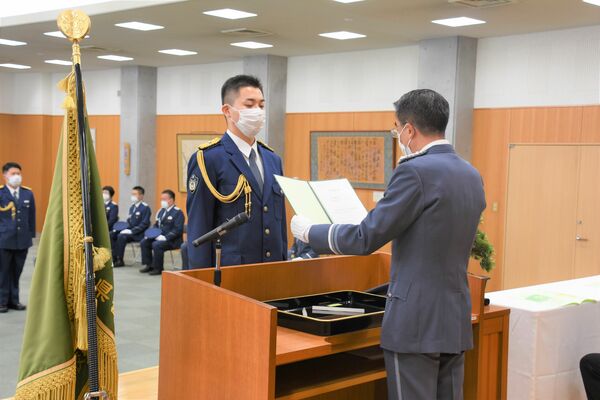 卒業証書を受け取る卒業生総代の小又巡査（左）＝28日午前、宇都宮市若草２丁目