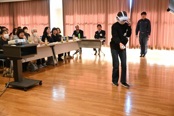 ゴーグルを装着し、ＡＲで示された火災の消火に挑戦する参加者