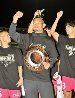 Ｊ３優勝を決め、シャーレを手にサポーターに向けて拳を掲げる主将の内田＝１１月２９日、相模原ギオンスタジアム