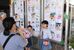 展示された絵画の前で記念撮影をする家族連れ＝８日午前、宇都宮市インターパーク６丁目