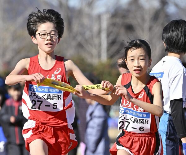 よろしく真岡Rの5区・石川(左)がアンカー・山口にたすきをつなぐ=ニッコークリエートスポーツフィールドとちぎ、広瀬華撮影