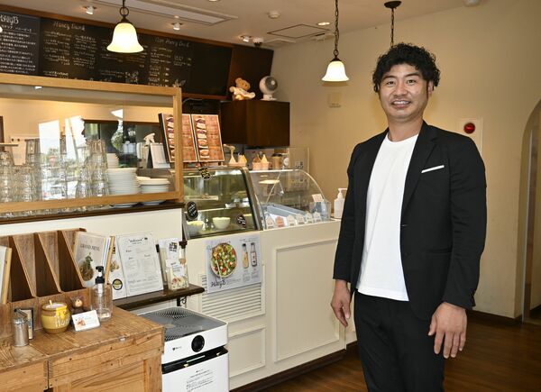 蜂蜜を使った料理を提供する「ハニービー」の店内に立つ黒田社長＝鹿沼市