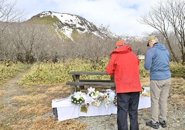 雪崩事故の発生現場を望む献花台で手を合わせる人たち＝27日午前８時５分、那須町湯本、広瀬華撮影