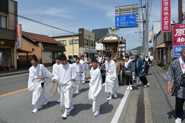 白張姿で山車を引く高校生たち