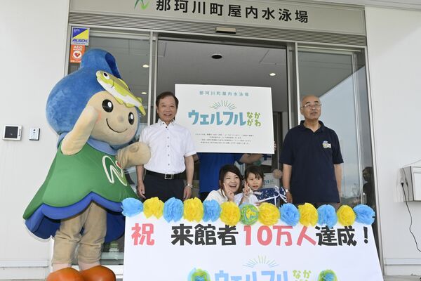 10万人目の来場者で記念品を受け取った磯尾さん親子（中央）