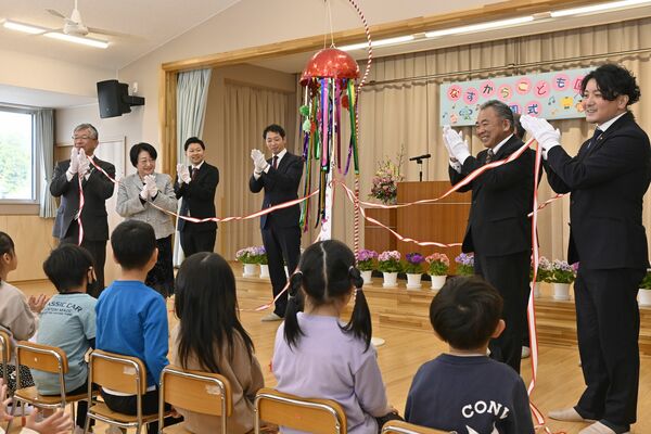 くす玉を割って開園を祝う関係者ら