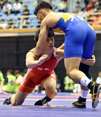 レスリング少年男子フリースタイル71キロ級準決勝　果敢にタックルを仕掛ける足大付の本橋（左）＝鹿児島県日置市の吹上浜公園体育館
