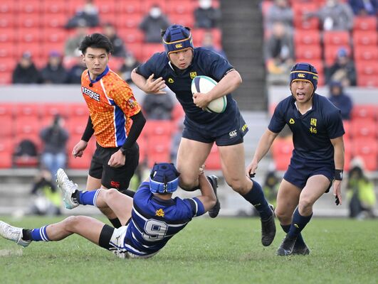 後半22分、突進する国学栃木のＣＴＢ根岸（中央）＝大阪府東大阪市の花園ラグビー場、広瀬華撮影