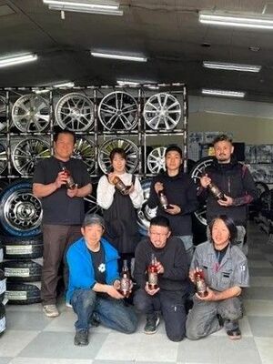 ウイスキー「湊 SOU」を手にする塚田社長(後列左)とロードランナーの従業員