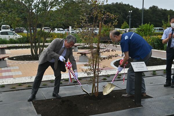 病院設立１０周年を記念して植樹を行う浅野市長（左）と島田理事長（右）