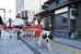 サンタクロースの仮装をしてパレードする犬と参加者