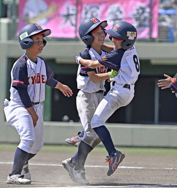５回、共英ＪＢＣの室井（中央）がコールド勝ちを決める２点適時二塁打を放って仲間に迎えられる＝エイジェックスタジアム、森田大地撮影