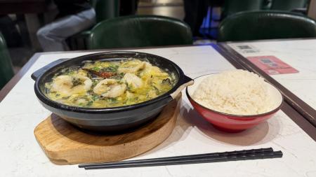 　上海の食堂で提供された鍋料理の「酸菜魚」（左）と白飯＝２月２４日