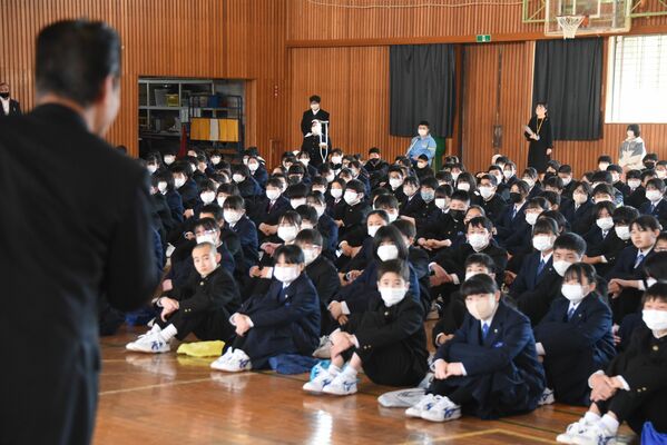 始業式で柳田校長（左）の話を聞く真岡中の生徒たち。マスクを外している姿は少数だった＝10日午前、真岡市並木町３丁目