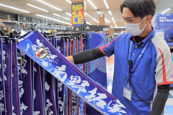 拡大した特設コーナーでグッズを整理するスポーツ用品店員＝24日午後、宇都宮市陽東８丁目