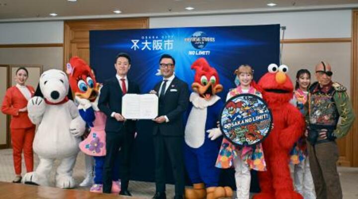 包括連携協定の締結式で、記念写真に納まるUSJと大阪市の関係者=12日午前、大阪市役所