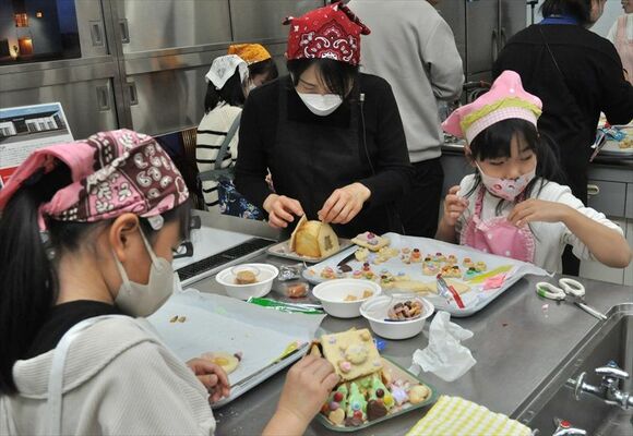 お菓子の家づくりに熱中する参加者たち