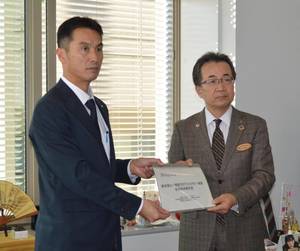 事業経過報告書を手渡すＮＴＴ東日本栃木支店の小林支店長（左）と小竹欣男県産業労働観光部長＝１日午後、県庁