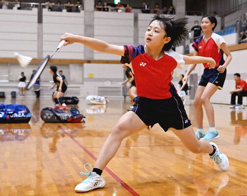 バドミントン女子ダブルス決勝リーグ　皆川・田中組（ＮＡＮＡＨＡジュニア）－鈴木・志賀組（ＯＮＥ）戦　第２ゲーム、皆川がバックでレシーブ。右奥は田中＝県南体育館