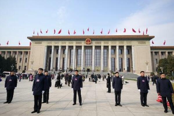 北京の人民大会堂の前で警戒する治安当局者ら=3月