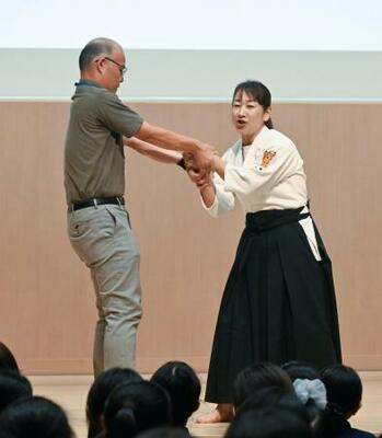 痴漢や盗撮の被害防止を目的とした防犯イベントで、護身術を実演する女性警察官(右)=15日午後、東京都品川区の品川女子学院