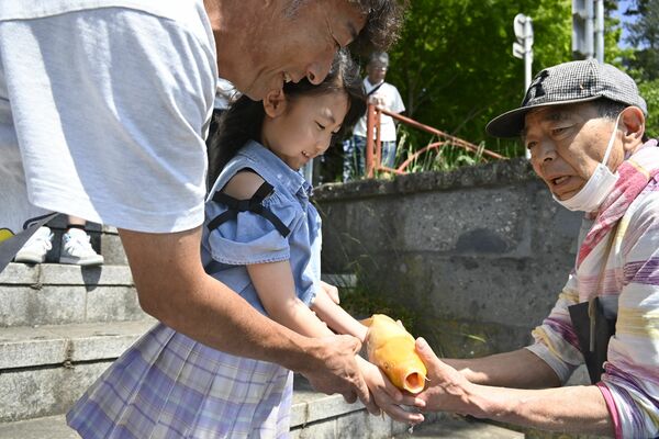 大前恵比寿神社の神使祭子供祭で川魚を放流する子ども＝５日午前10時20分、真岡市東郷
