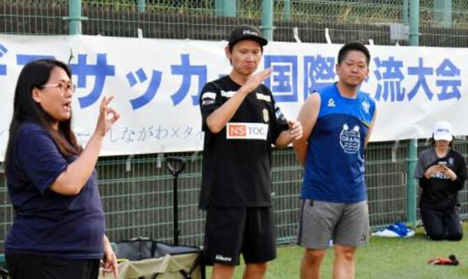 　交流キャンプで手話を使いコミュニケーションを取るデフサッカー男子日本代表元監督の植松隼人さん（中央）＝８月、東京都品川区