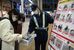 通行人に反射材などを配る警察官（右端）＝８日午後、宇都宮市江野町