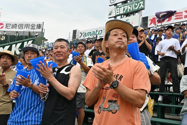 一塁側アルプススタンドで試合を見守った清水さん（前列右）と早川さん（同２人目）＝９日午後、阪神甲子園球場