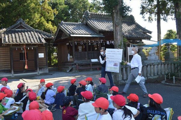 児童に町の歴史などについて説明する氏子総代会の役員ら