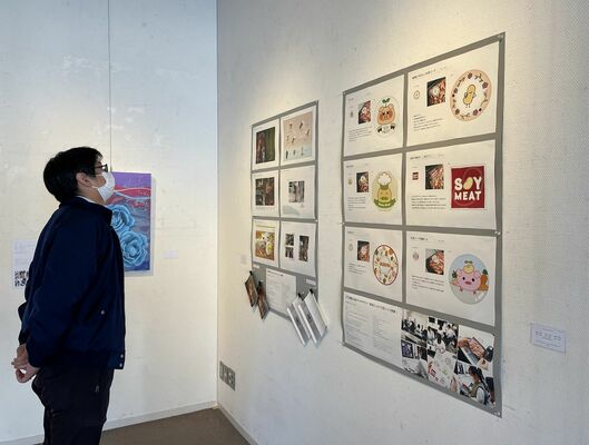 ポップな商品ラベルデザインなど学生の学びの成果が並ぶ作品展＝12日午前、宇都宮市上戸祭４丁目