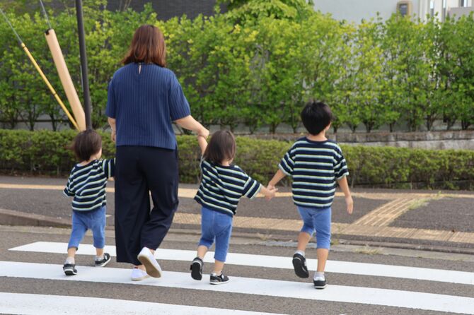 同じ保育施設に通えない双子の息子の手を引く女性(左から2人目)。送迎などの負担は大きく、行政に改善を訴える=9月7日午後、仙台市泉区